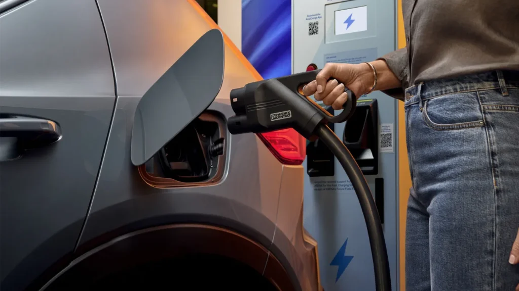 a woman plugging in a fast EV charger