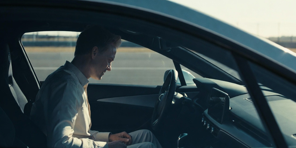 A man closely observing a used car interior and functions