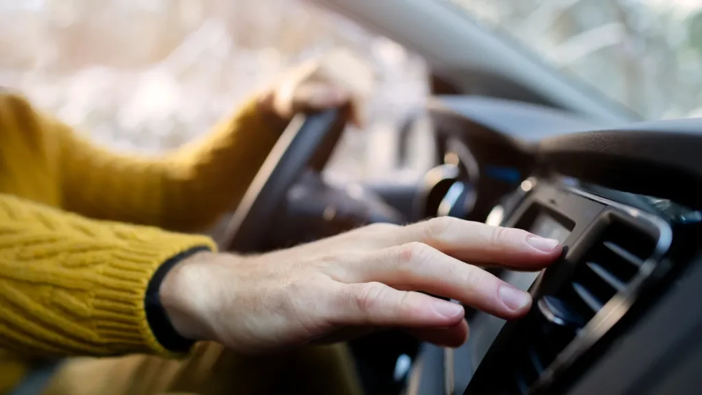 A man checking the cars air conditioner