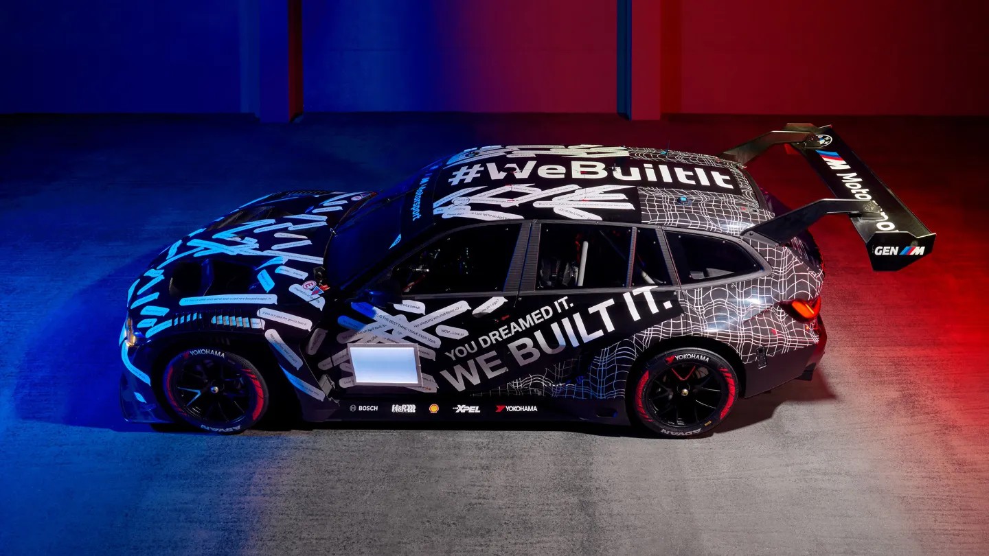 BMW M3 Touring 24H in a garage with red blue lighting