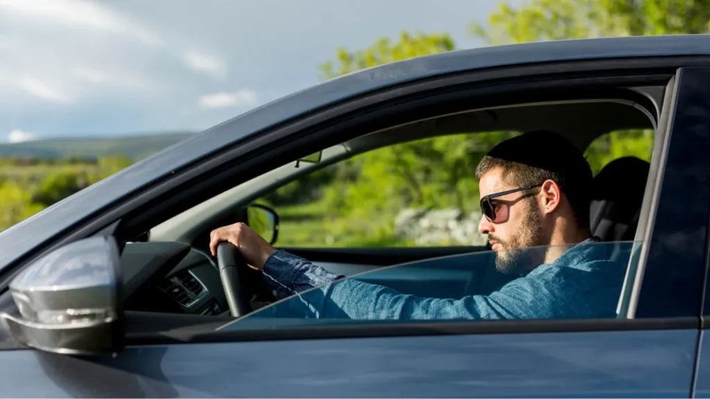 a man driving a car with a window open