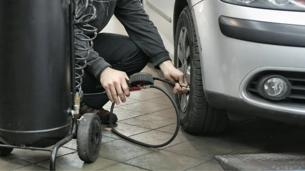 a man filling air in the front car tyre
