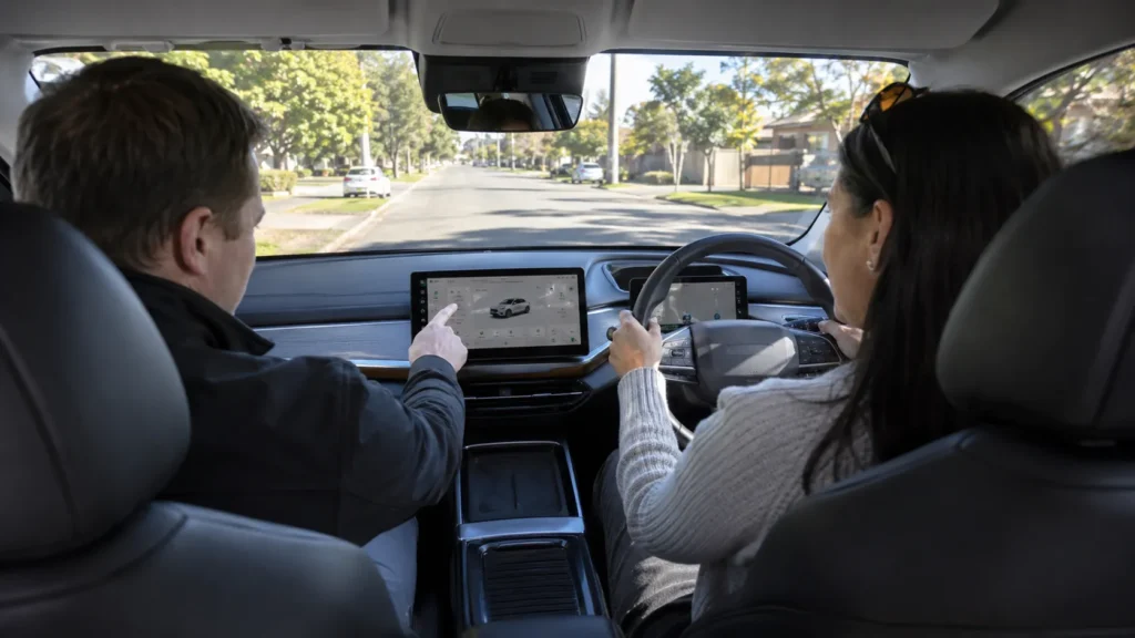 A customer test driving an EV with a car dealership official