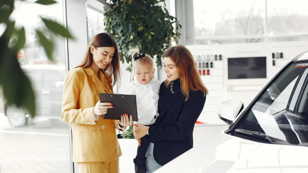 A new mother in a car dealership buying a car