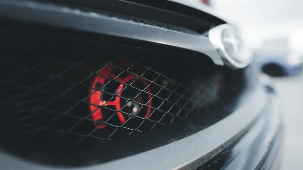 a close up of a red accent car horn on a Subaru