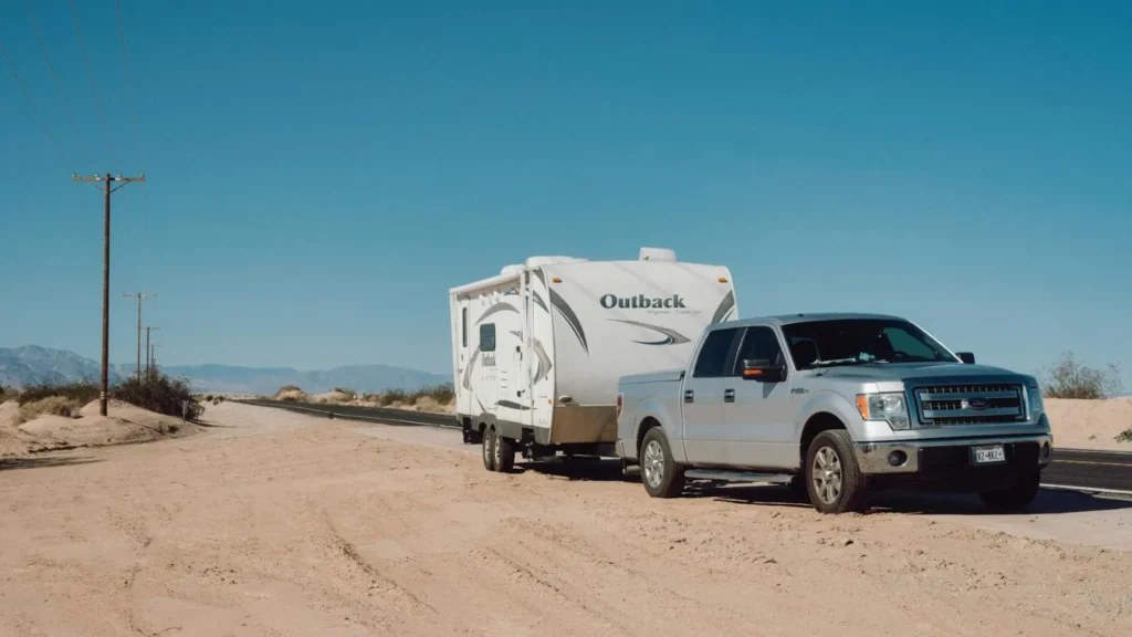 a ford ute towing a caravan in the outback