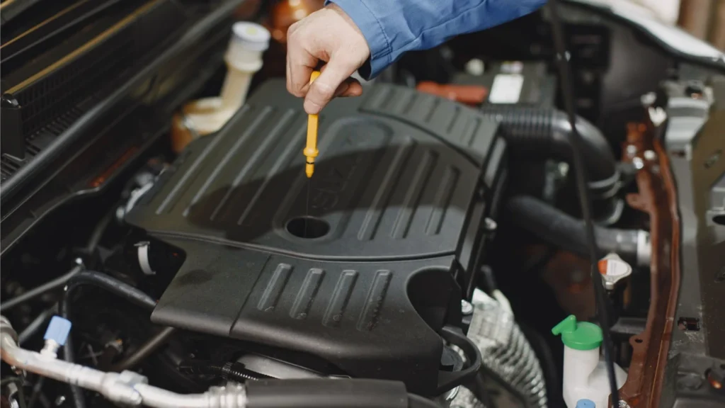 Using dip stick to check car engine oil