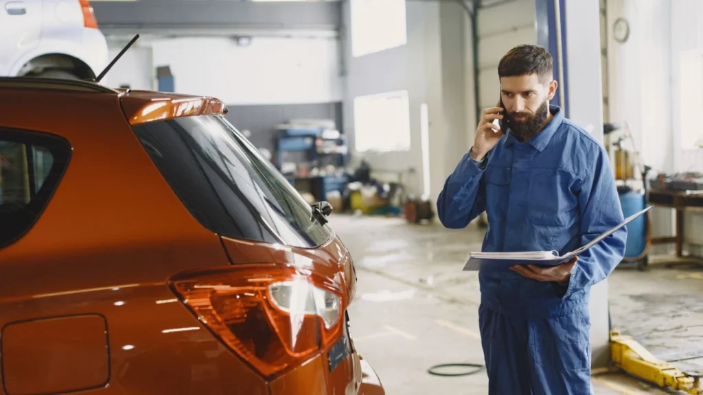 A mechanic holding the car service logbook paper booklet